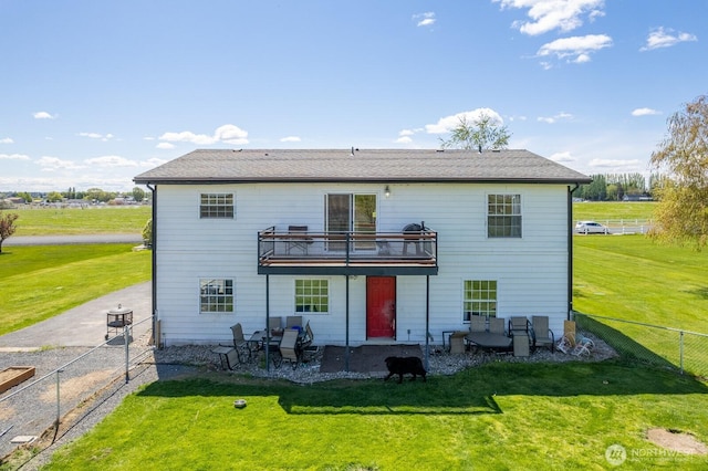rear view of property featuring a yard, a fenced backyard, and a patio area