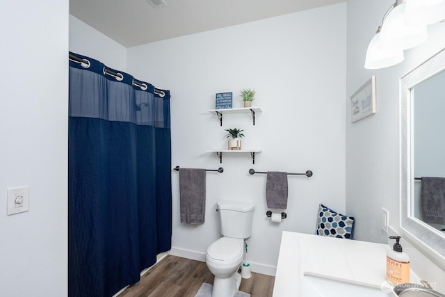 full bathroom with vanity, wood finished floors, toilet, baseboards, and a shower with shower curtain