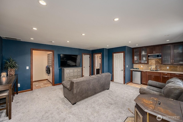 living room with visible vents, light colored carpet, baseboards, indoor wet bar, and recessed lighting