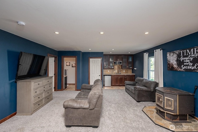 living area featuring recessed lighting, baseboards, and light carpet
