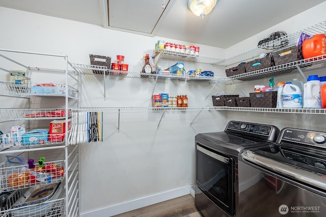 washroom featuring laundry area, wood finished floors, baseboards, attic access, and independent washer and dryer