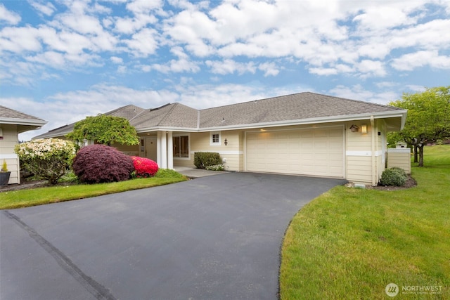 ranch-style house with asphalt driveway, a garage, and a front lawn