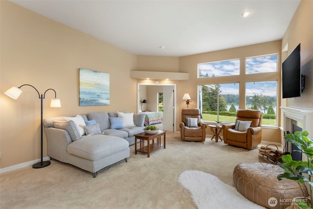 living room featuring light carpet, healthy amount of natural light, and a fireplace