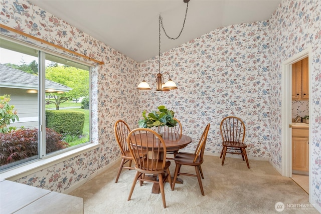 dining room featuring wallpapered walls, plenty of natural light, light carpet, vaulted ceiling, and baseboards