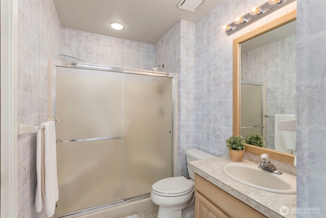 bathroom with a stall shower, vanity, and toilet