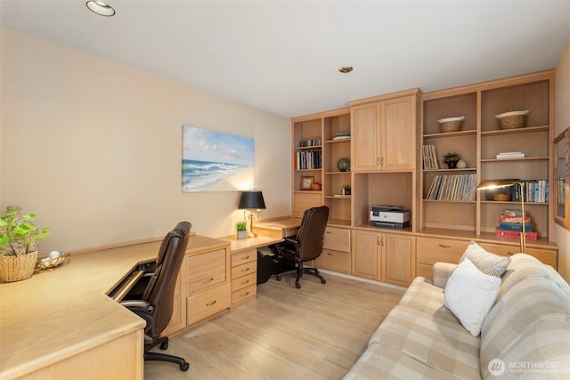 home office featuring light wood finished floors, built in desk, and recessed lighting