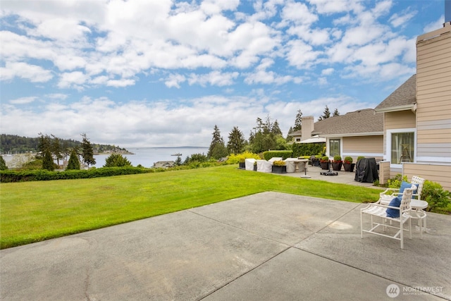view of green lawn featuring a water view, a patio area, and outdoor lounge area