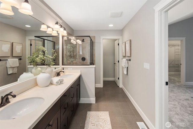 full bath featuring double vanity, baseboards, a shower stall, and a sink