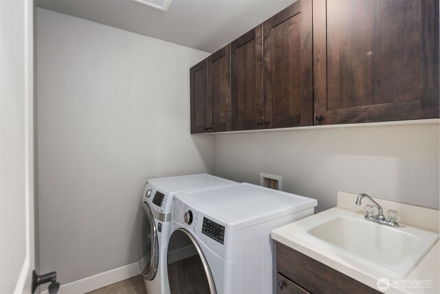 laundry area with a sink, baseboards, cabinet space, and washer and dryer