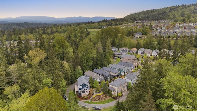 drone / aerial view featuring a view of trees, a residential view, and a mountain view