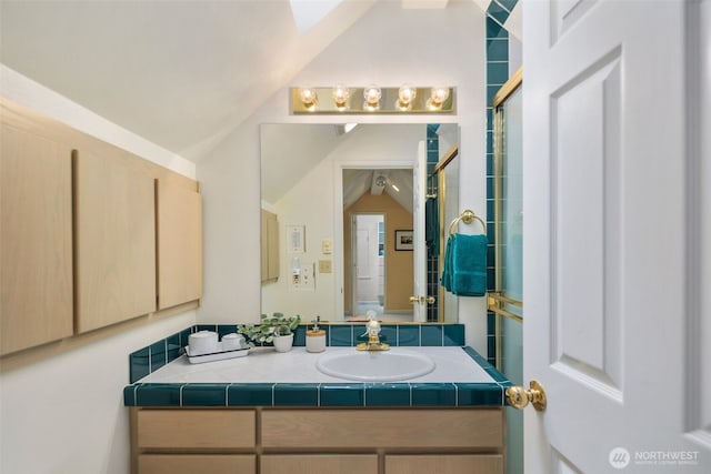 bathroom with vanity, vaulted ceiling, and a tile shower