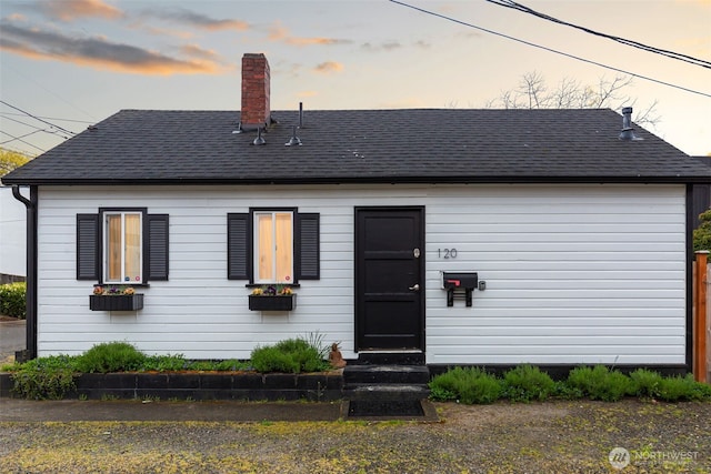 view of front of property with roof with shingles, a chimney, and entry steps