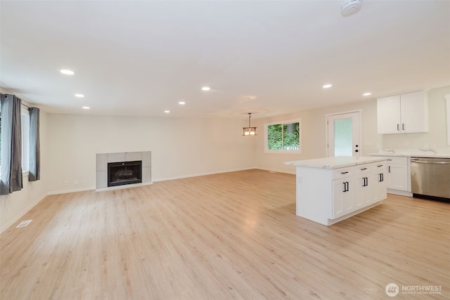 kitchen featuring stainless steel dishwasher, light wood-style flooring, and open floor plan