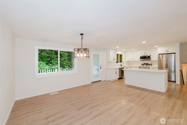 kitchen with white cabinetry, appliances with stainless steel finishes, and light wood-type flooring