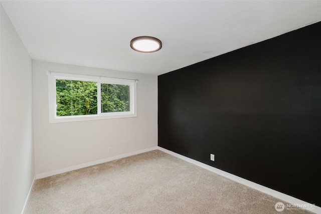 carpeted empty room featuring baseboards