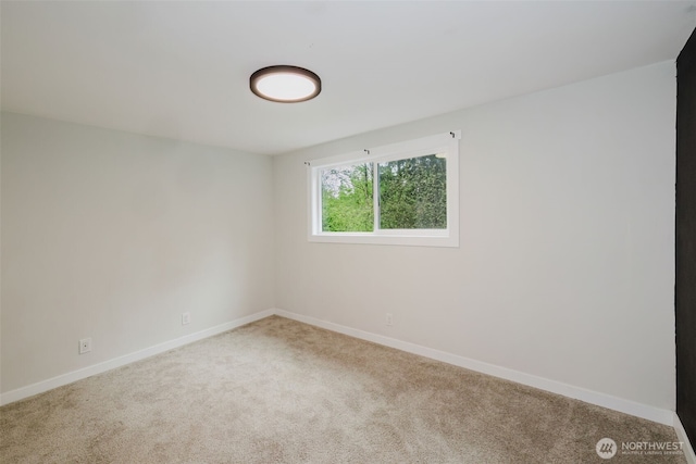 spare room featuring carpet floors and baseboards