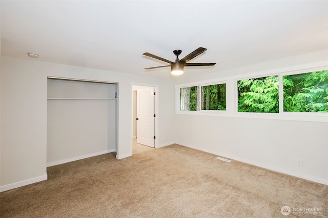 unfurnished bedroom with baseboards, visible vents, carpet, and a closet