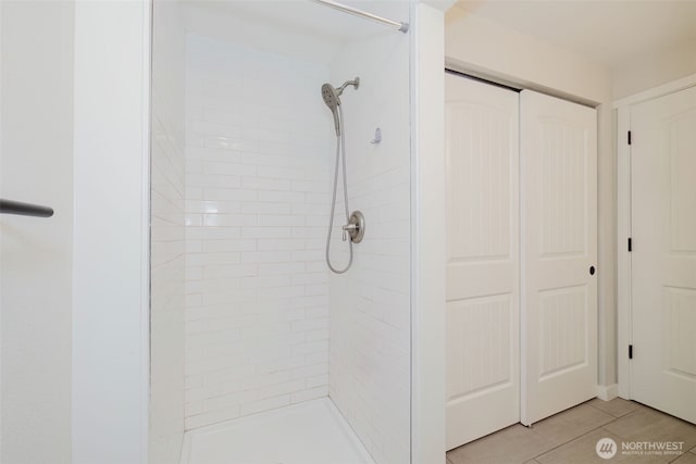 full bath featuring tile patterned floors and tiled shower
