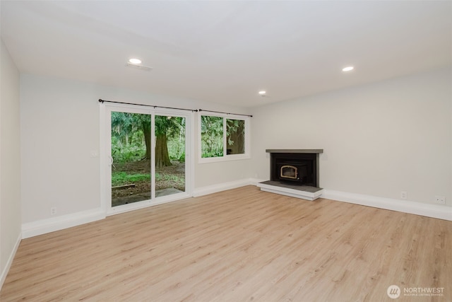 unfurnished living room featuring recessed lighting, baseboards, and wood finished floors