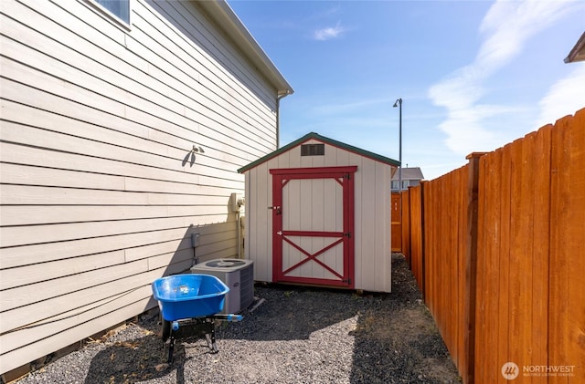 view of shed featuring cooling unit and a fenced backyard