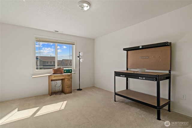 office with light colored carpet, a textured ceiling, baseboards, and visible vents