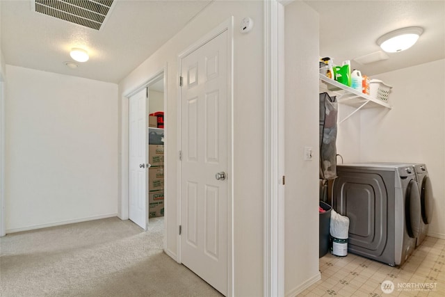 clothes washing area featuring laundry area, washer and clothes dryer, baseboards, and visible vents