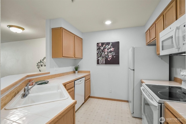 kitchen featuring a peninsula, white appliances, light floors, tile countertops, and a sink
