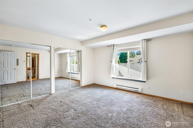 unfurnished bedroom with baseboard heating, baseboards, a baseboard radiator, two closets, and carpet