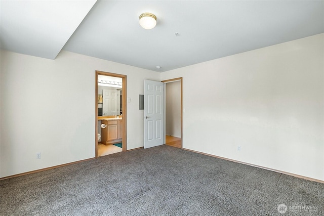 unfurnished bedroom with baseboards, connected bathroom, and light carpet