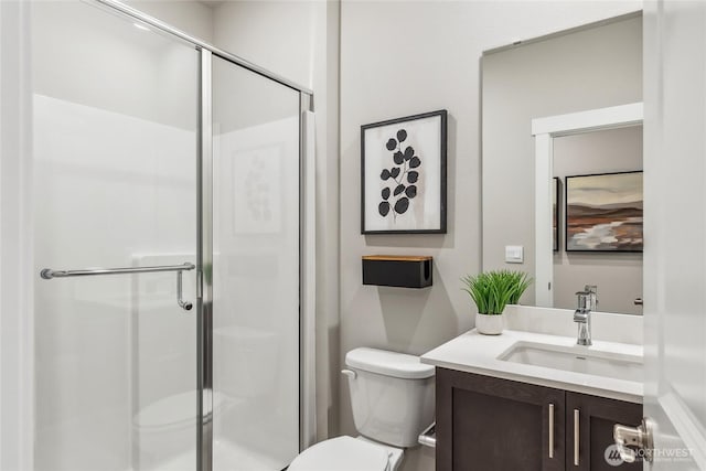 bathroom with toilet, a shower stall, and vanity