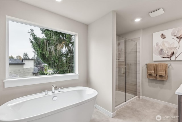 bathroom featuring baseboards, a freestanding bath, and a stall shower