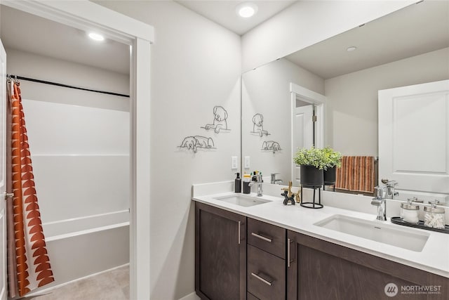 full bathroom with a sink, shower / bath combo with shower curtain, recessed lighting, and double vanity