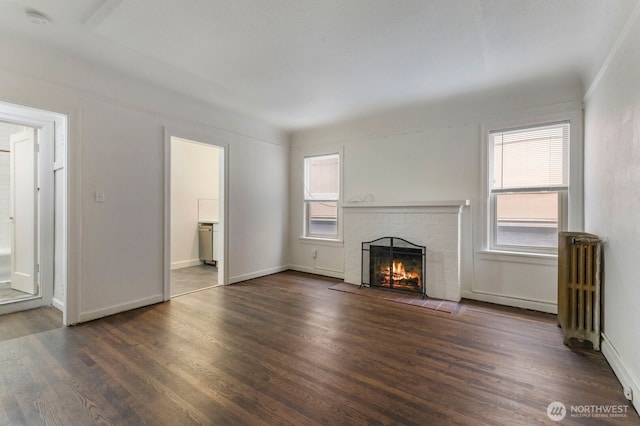5234 University Way NE, Seattle, WA 98105 - unfurnished living room featuring radiator, baseboards, a brick fireplace, and wood finished floors