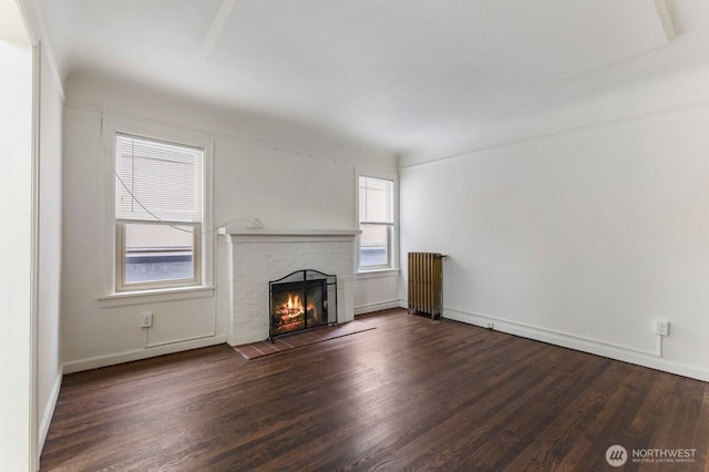 5234 University Way NE, Seattle, WA 98105 - unfurnished living room with plenty of natural light, radiator, a brick fireplace, and wood finished floors