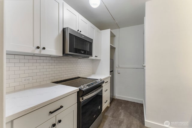 5234 University Way NE, Seattle, WA 98105 - kitchen with dark wood-style flooring, light stone countertops, stainless steel appliances, white cabinetry, and tasteful backsplash