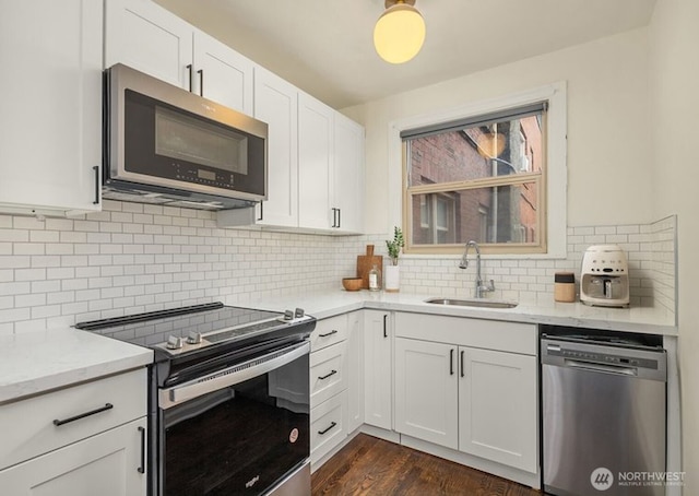 5234 University Way NE, Seattle, WA 98105 - kitchen with decorative backsplash, a sink, dark wood-style floors, stainless steel appliances, and white cabinetry