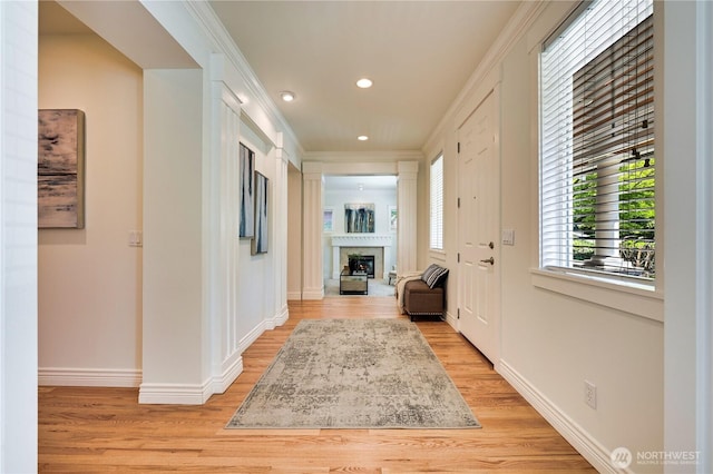 6722 Azalea Way SE, Snoqualmie, WA 98065 - entryway with a fireplace, light wood finished floors, baseboards, recessed lighting, and crown molding