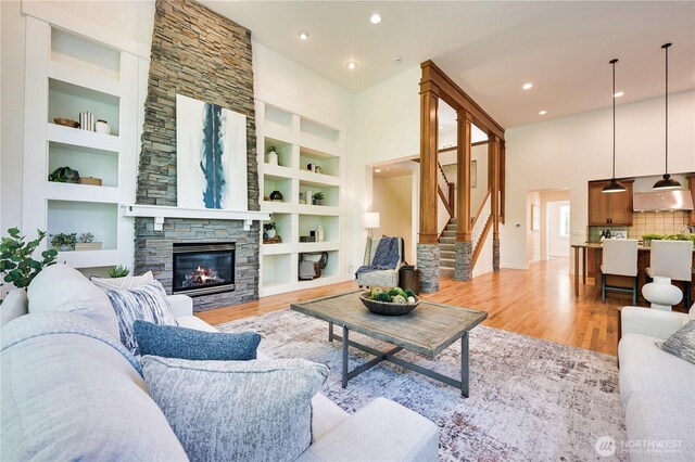 6722 Azalea Way SE, Snoqualmie, WA 98065 - living room featuring light wood-style flooring, built in features, recessed lighting, stairs, and a stone fireplace