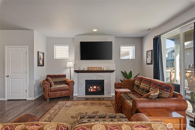 9957 Justman St SE, Yelm, WA 98597 - living area featuring a healthy amount of sunlight, baseboards, a lit fireplace, and wood finished floors