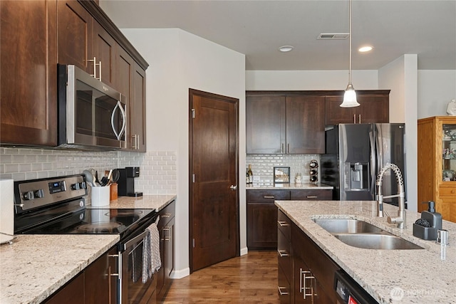 9957 Justman St SE, Yelm, WA 98597 - kitchen with visible vents, dark brown cabinetry, a sink, dark wood finished floors, and stainless steel appliances