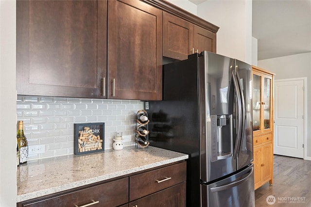 9957 Justman St SE, Yelm, WA 98597 - kitchen with tasteful backsplash, light stone countertops, stainless steel refrigerator with ice dispenser, and dark wood-type flooring