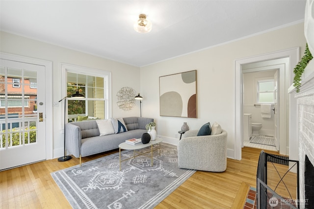 living room with baseboards, ornamental molding, and wood finished floors