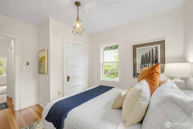 bedroom featuring light wood-style floors, baseboards, and crown molding