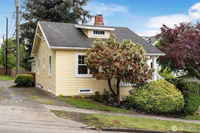 view of front of property with fence, a chimney, and roof with shingles