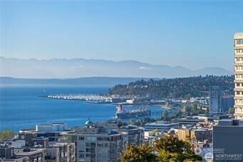 property's view of city with a water and mountain view