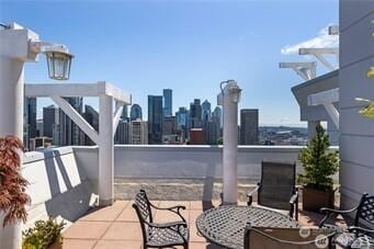 view of patio / terrace featuring a view of city and outdoor dining area
