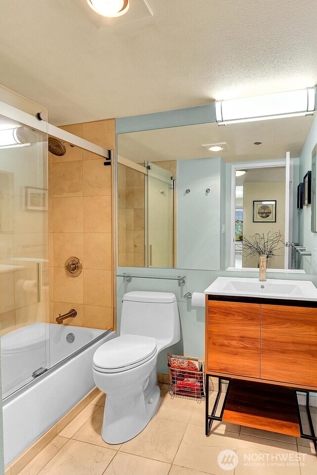 full bath with toilet, tile patterned floors, combined bath / shower with glass door, and vanity