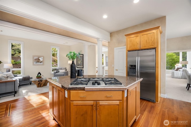 kitchen with appliances with stainless steel finishes, a wealth of natural light, a kitchen island, and open floor plan