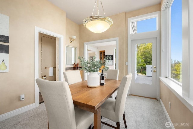 dining room featuring baseboards and light colored carpet