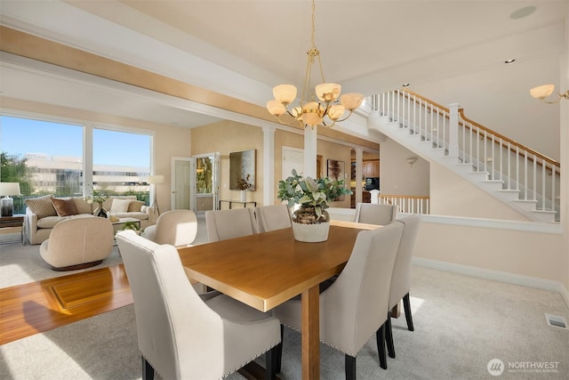 dining room with baseboards, carpet, a chandelier, and stairway